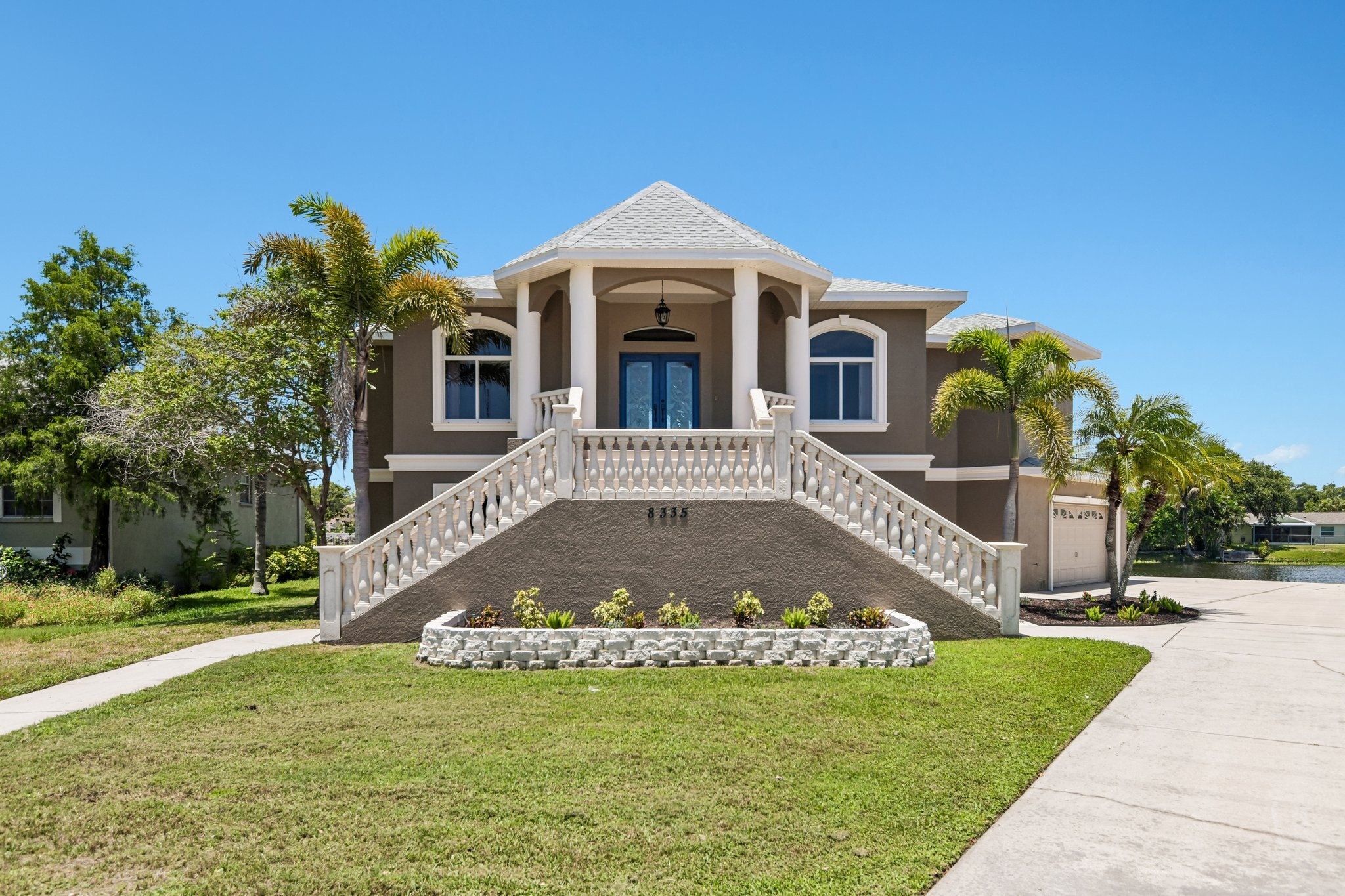 Front exterior of 8335 Cheyenne Dr, a custom-built 4 bedroom waterfront estate for sale in Seminole, FL 33777