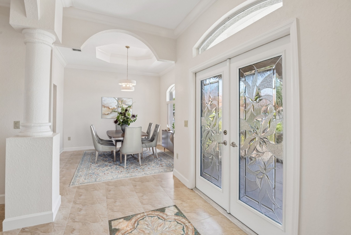 Elegant formal dining room with arched windows and French doors at 8335 Cheyenne Dr, Seminole FL 33777