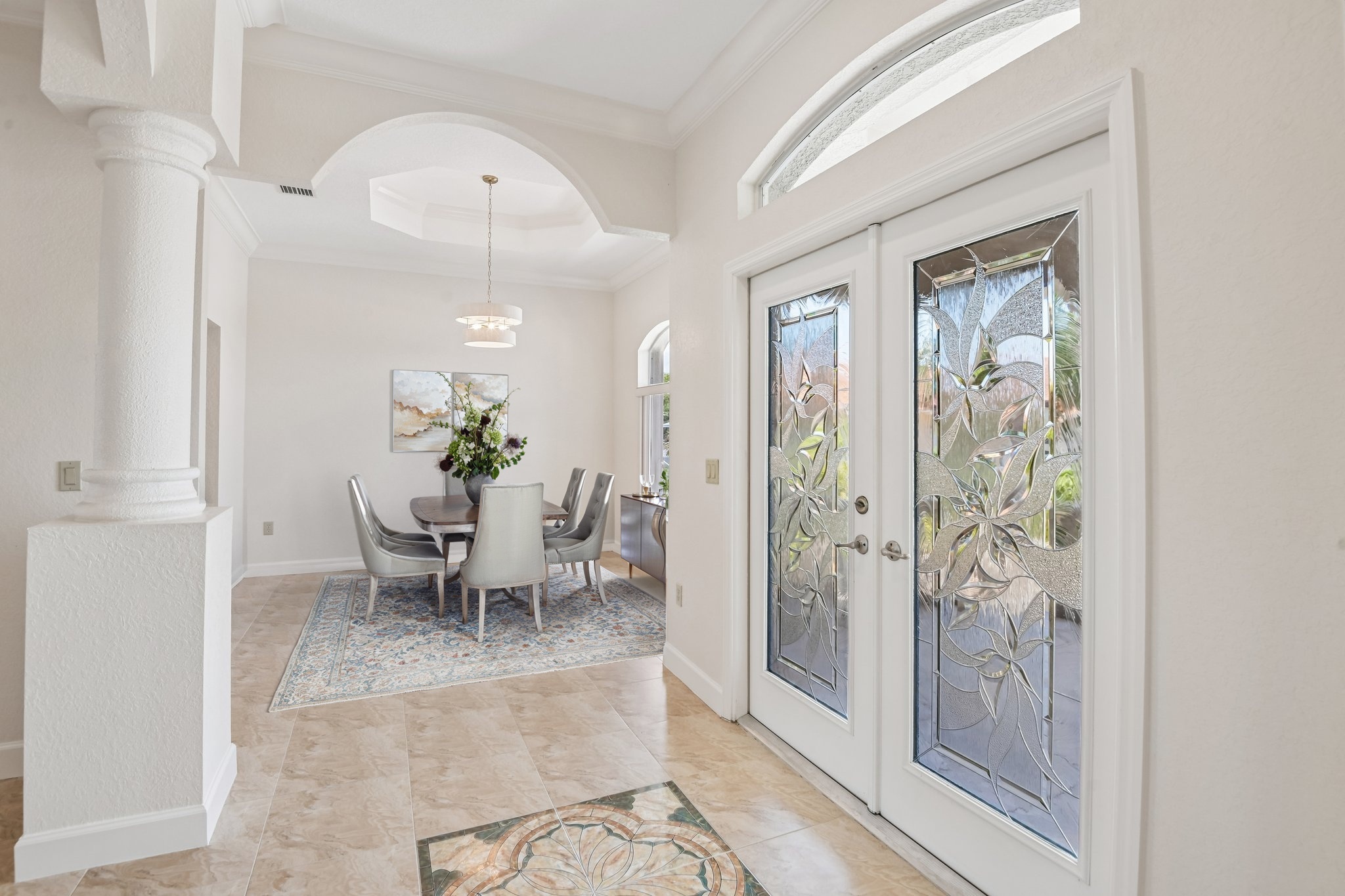 Elegant formal dining room with arched windows and French doors at 8335 Cheyenne Dr, Seminole FL 33777
