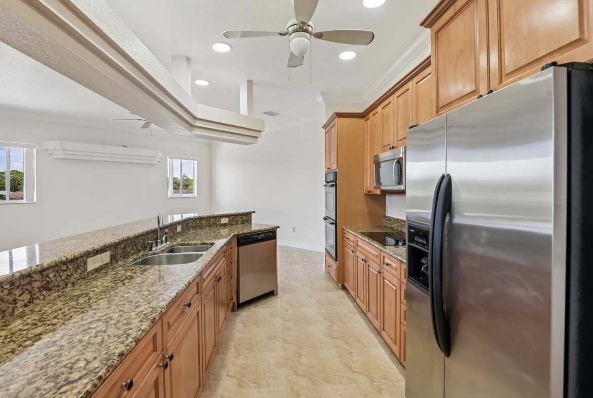 Gourmet kitchen with maple cabinetry, granite countertops and stainless appliances in Seminole FL 33777