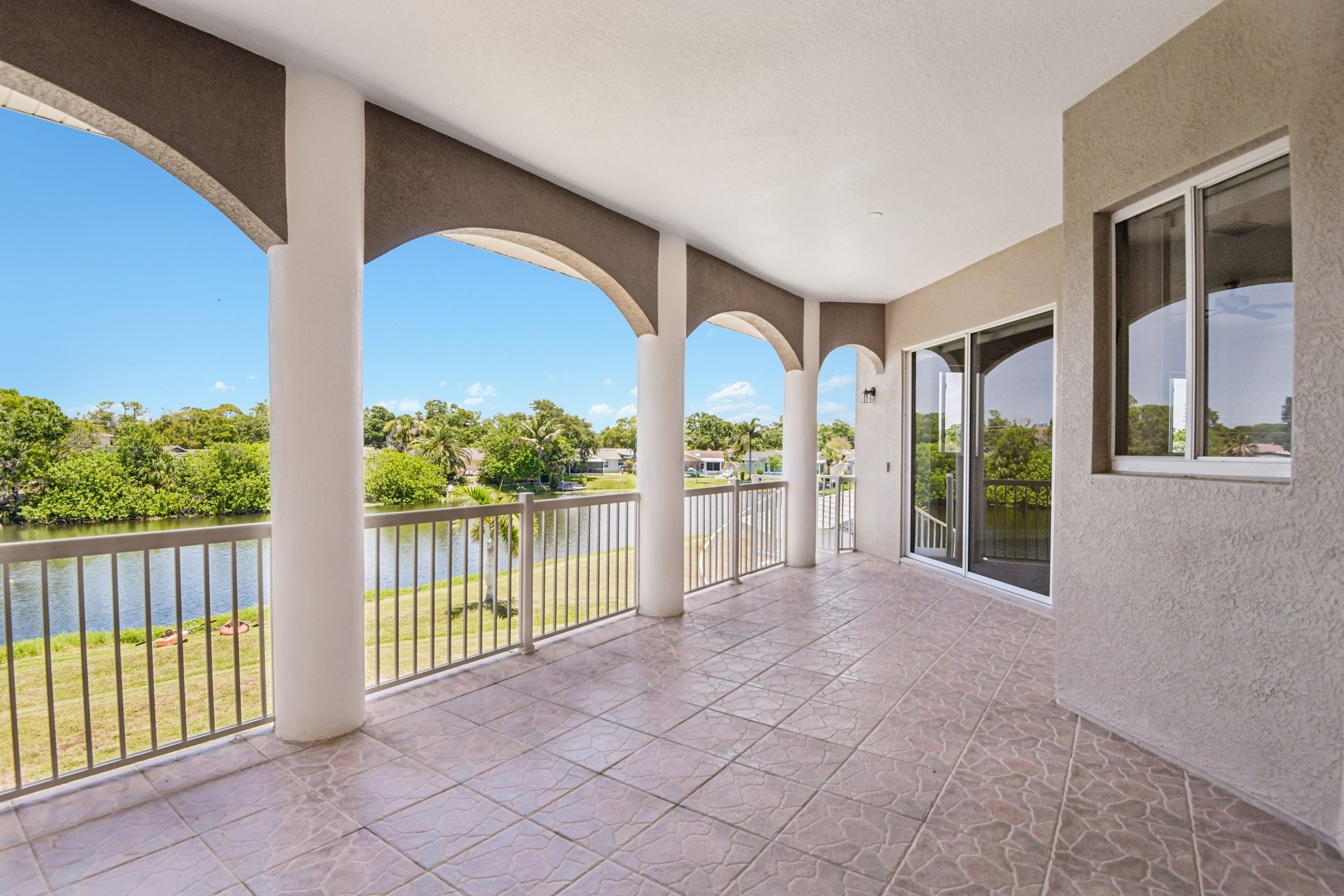 Covered balcony with arched columns and canal views at 8335 Cheyenne Dr, Seminole FL