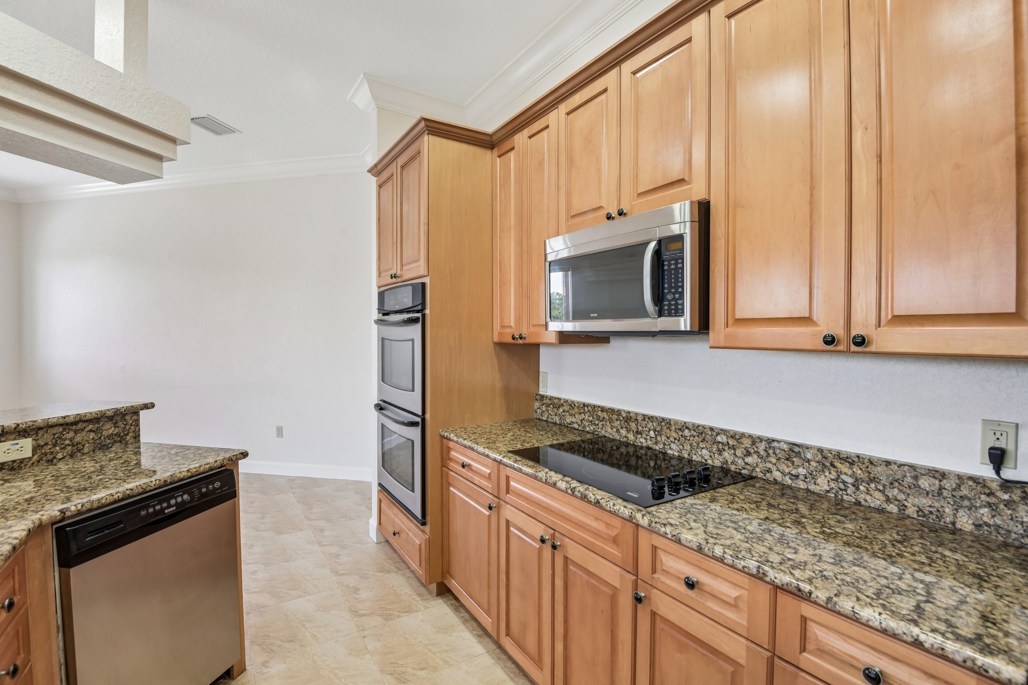 Kitchen with rich maple cabinetry, granite counters and stainless appliances in Seminole FL