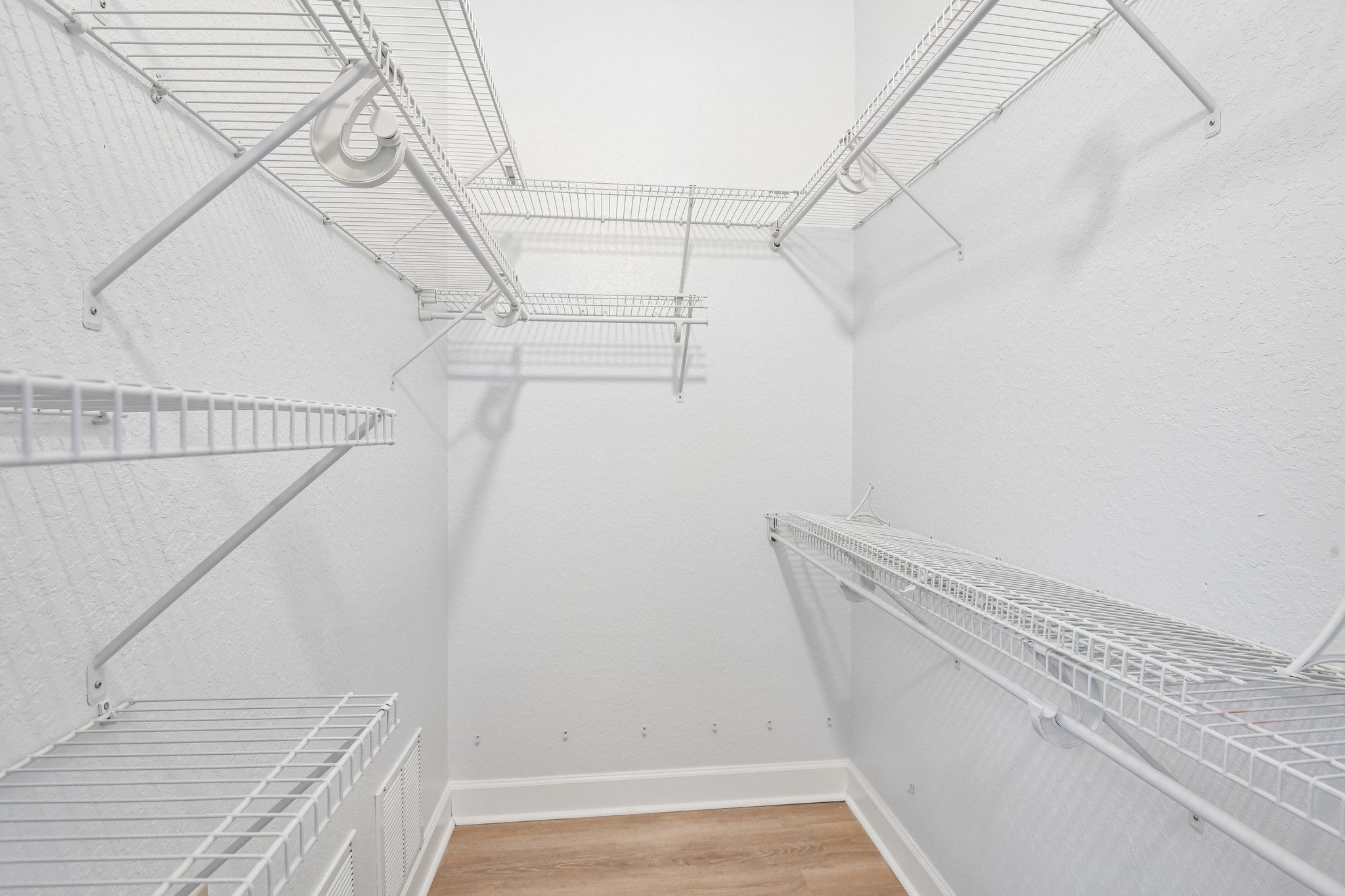 Large walk-in closet with custom shelving in the primary suite at 8335 Cheyenne Dr, Seminole FL