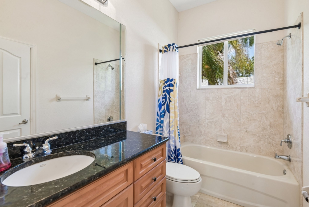 Guest bathroom with granite vanity and tub shower combination in Seminole FL
