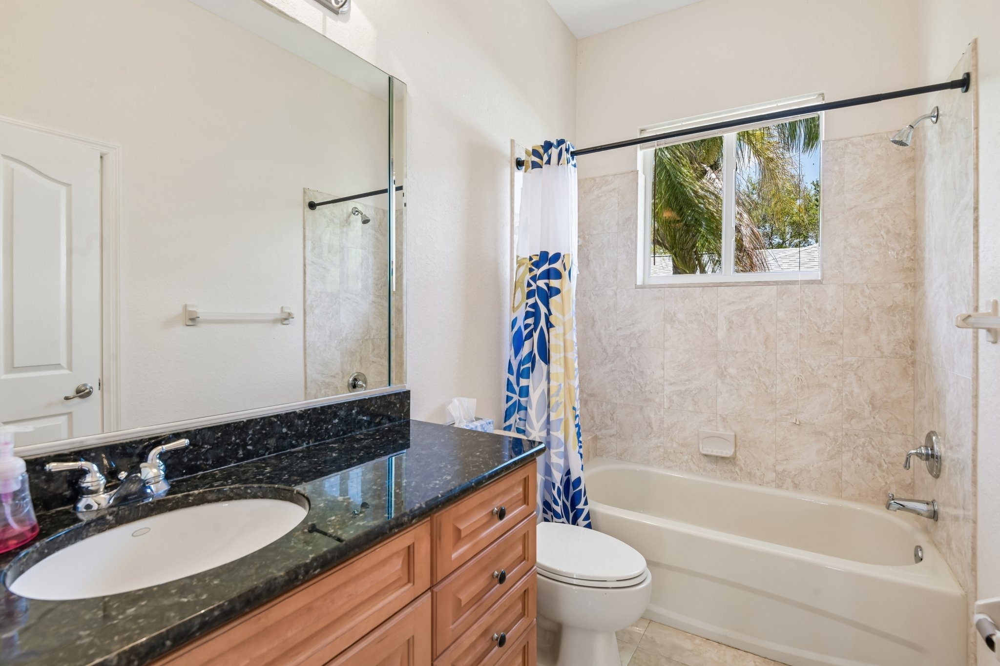 Guest bathroom with granite vanity and tub shower combination in Seminole FL
