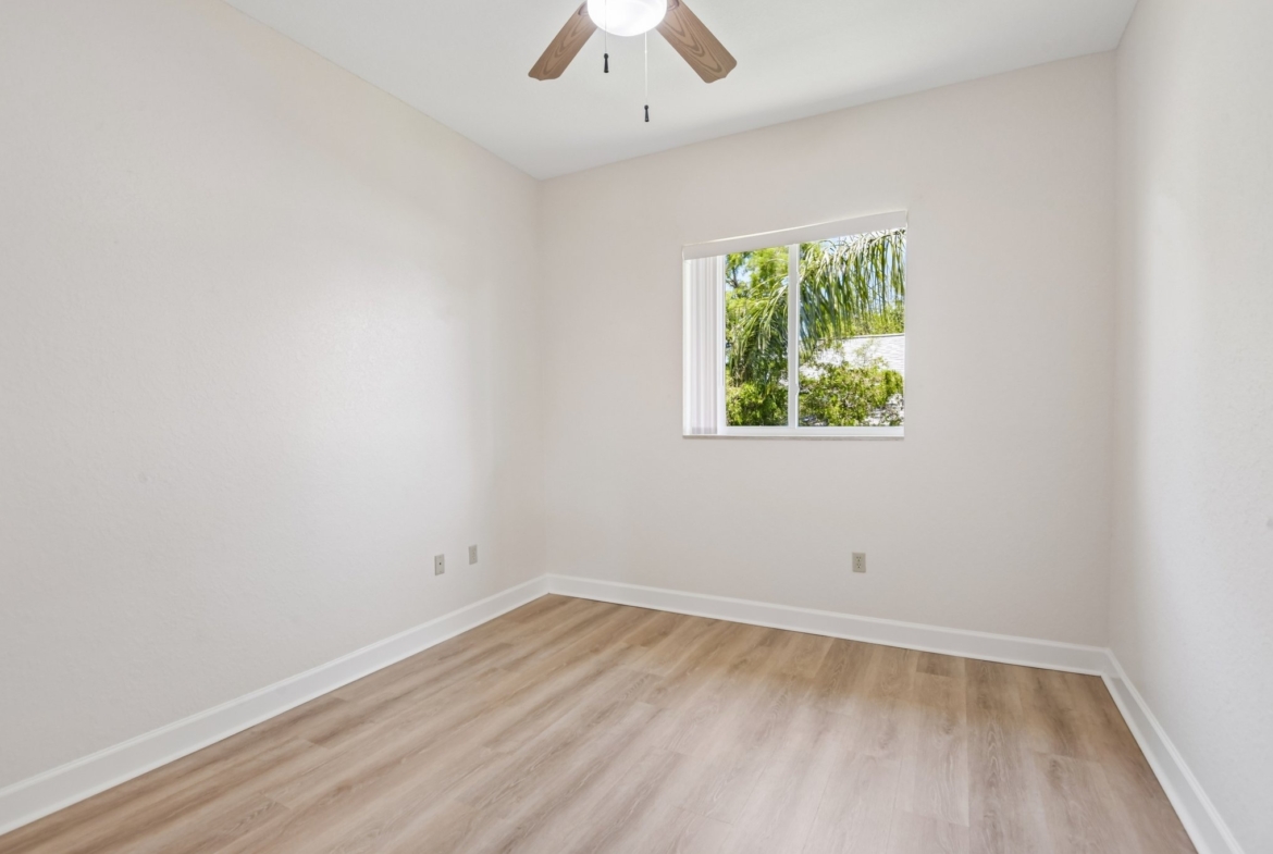 Fourth bedroom with ceiling fan and laminate flooring in this Seminole FL home for sale