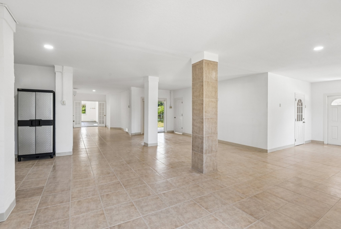 Lower level flex space with columns and tile flooring in this Seminole FL waterfront estate