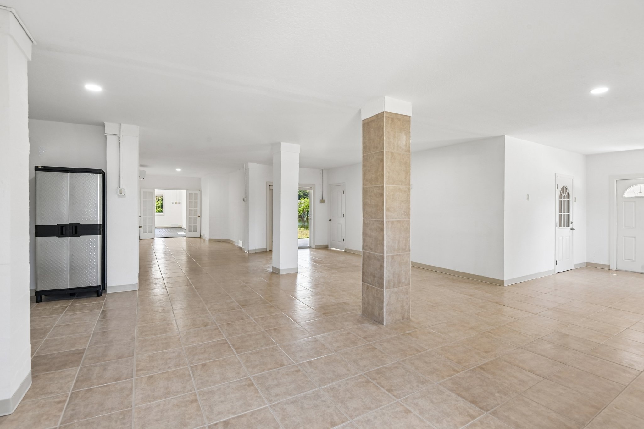 Lower level flex space with columns and tile flooring in this Seminole FL waterfront estate