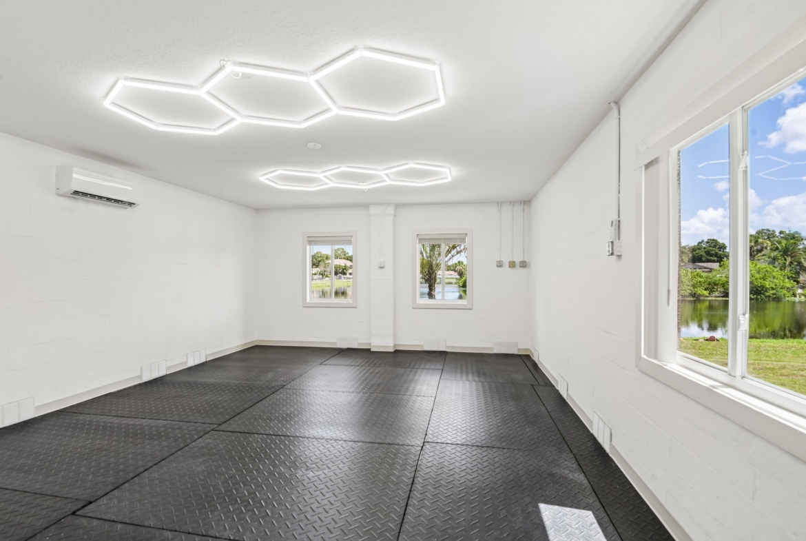 Lower level home gym with rubber flooring and water views at 8335 Cheyenne Dr, Seminole FL