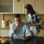 Couple reviewing mortgage bills at the kitchen table, considering a short sale